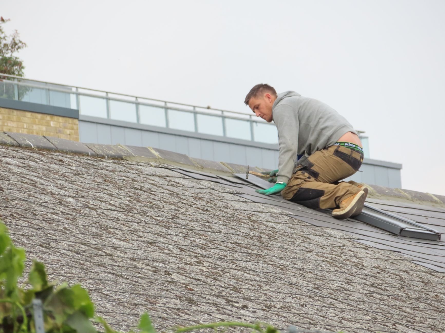 Worker on a shingle roof